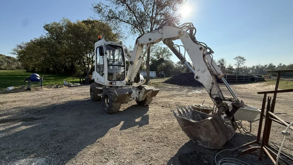 Tractopelle Mécalac en terrassement agricole sur une exploitation en Crau près d’Arles