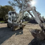 Tractopelle Mécalac en terrassement agricole sur une exploitation en Crau près d’Arles